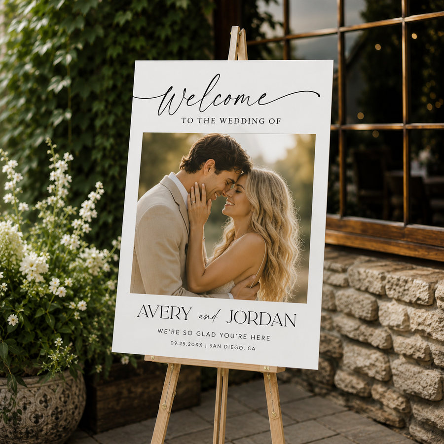 Wedding welcome sign with a photo of a couple and text on an easel outdoors.